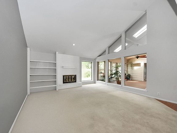 Living room with high ceilings, a fireplace, and plenty of natural light