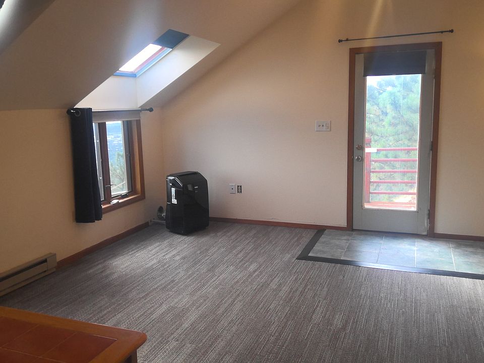 main living space with black portable A/C unit and blue tiled entry way