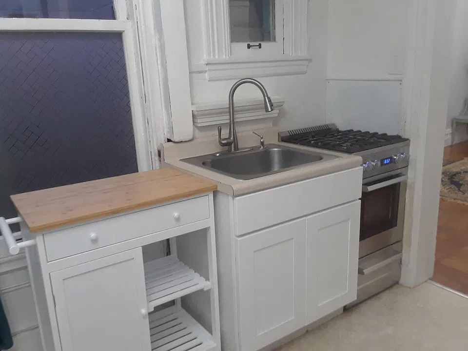 There is a countertop and cabinets opposite the stove. It is a small but adequate cooking area.