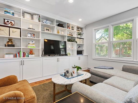 Family room has been updated with plantation shutters, built-in media center/book case, and flush li