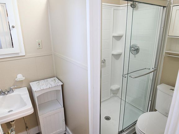 Updated bathroom includes spacious shower and ample storage spaces.