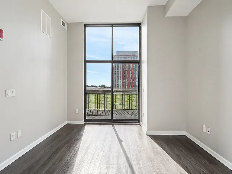 an empty living room with a door to a balcony