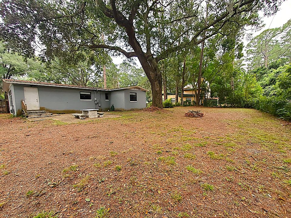 Large fenced backyard with concrete patio
