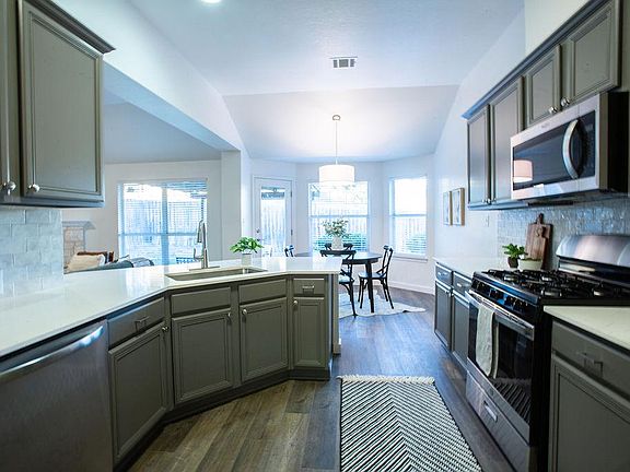Spacious kitchen and breakfast nook flow into living area.