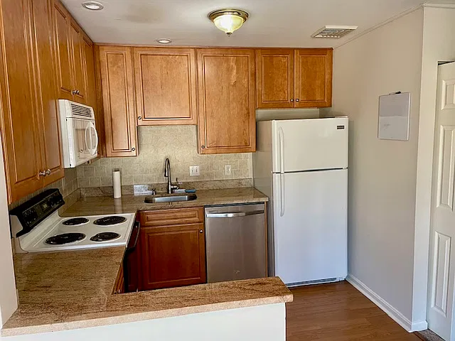 Kitchen refrigerator under counter lighting, lots of cabinet space for storage.