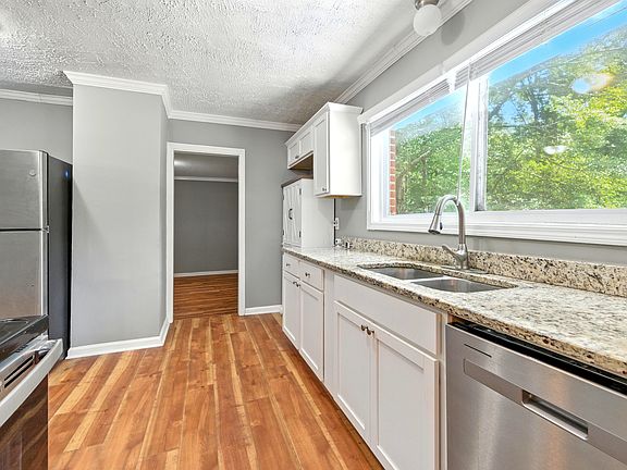 Sunlit Kitchen with brand-new stainless steel appliances. The wide kitchen window brings the outdoors in, filling the room with light and letting you stay connected to the family as you cook.