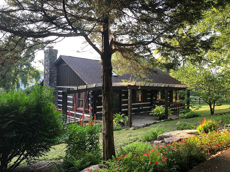 back of house with sitting area under arbor