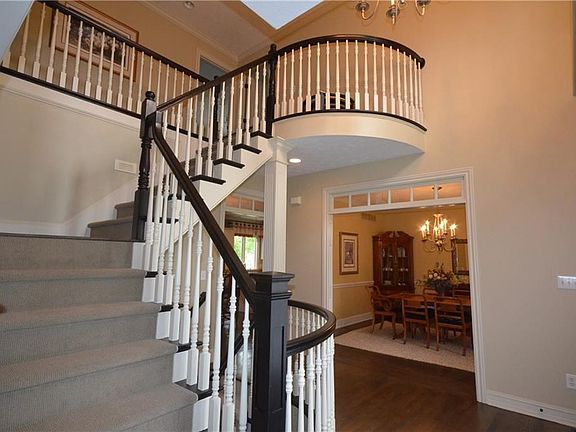 Staircase with hardwood stairs; large two story Entry Hall.