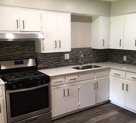 Kitchen is updated with stainless steel appliances, backsplash, recessed lighting and ceiling fan.