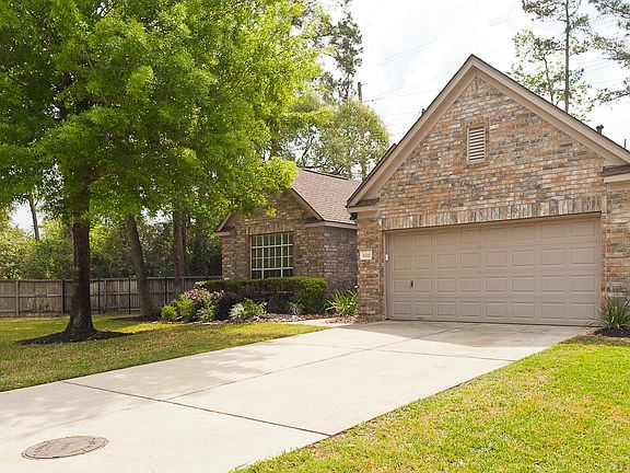 Another front view of the home, 2-car attached garage and several mature trees.