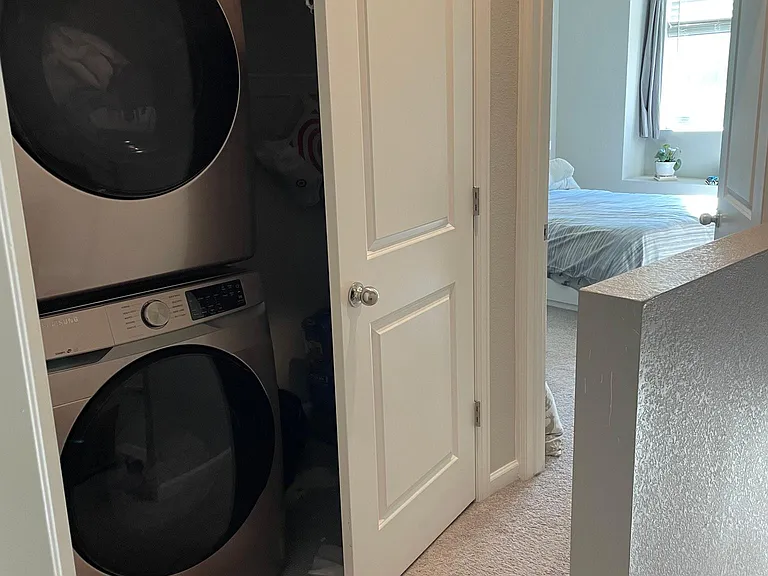 Stacked washer and dryer upstairs between bedrooms