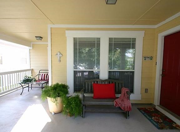 Large front porch welcomes you to the home and is perfect for enjoying a cup of coffee or watching t