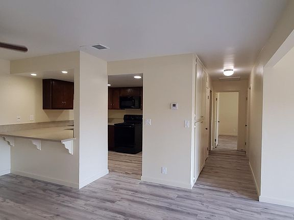 View of kitchen layout and proximity to hallway that leads to bedrooms. Hallway has large linen closets and 2 coat closets. Bedroom 2 is on the right, hall bathroom is on the left, and master bedroom and bathroom are at the end of the hallway.