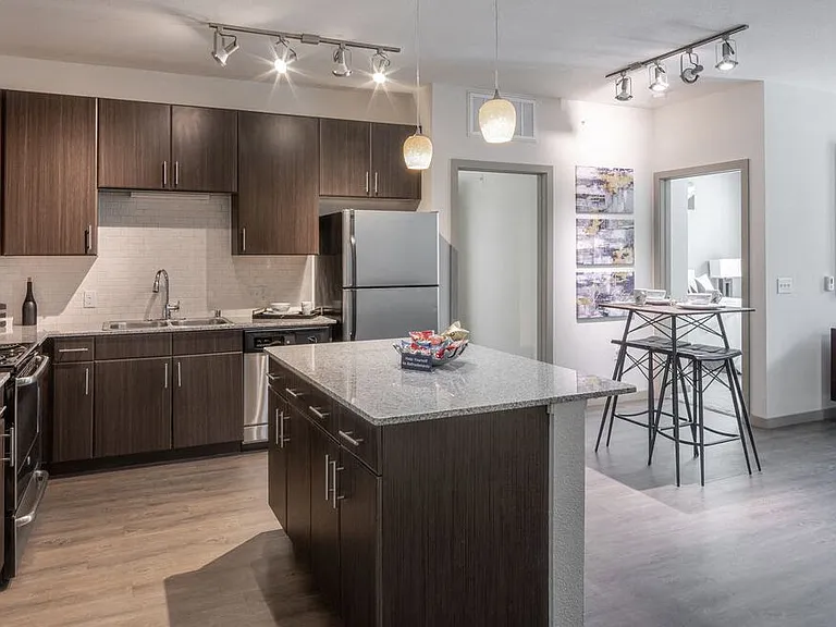 Centro Apartments model kitchen with brown cabinets and island