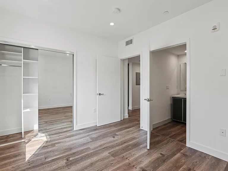 Bedroom with Mirrored Closet with Shelving, Vinyl Flooring, and Recessed Lighting