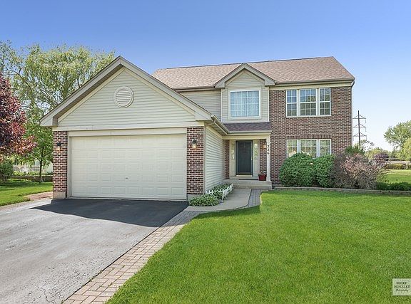 Long Driveway Bordered by Brick Pavers and Nestled on a Curve Street with Large Lot and Open Green S