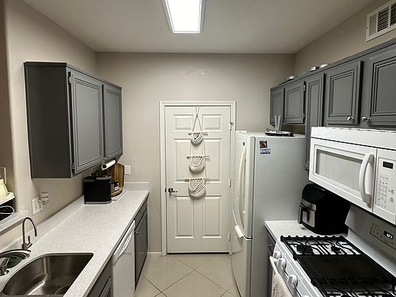 Kitchen, including garbage disposal, dishwasher, refrigerator, stove, oven, microwave. There is a reverse osmosis water filter built-in.
The door leads to pantry storage and washer/drier.