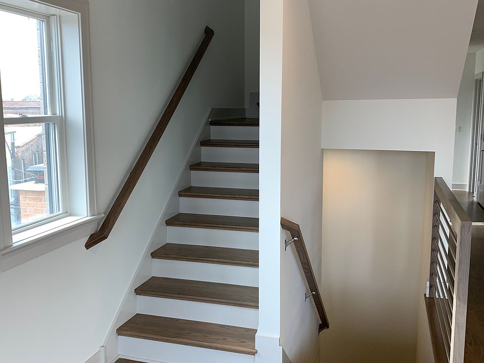 Staircase down to exit and up to loft/office area and hallway to rooftop.