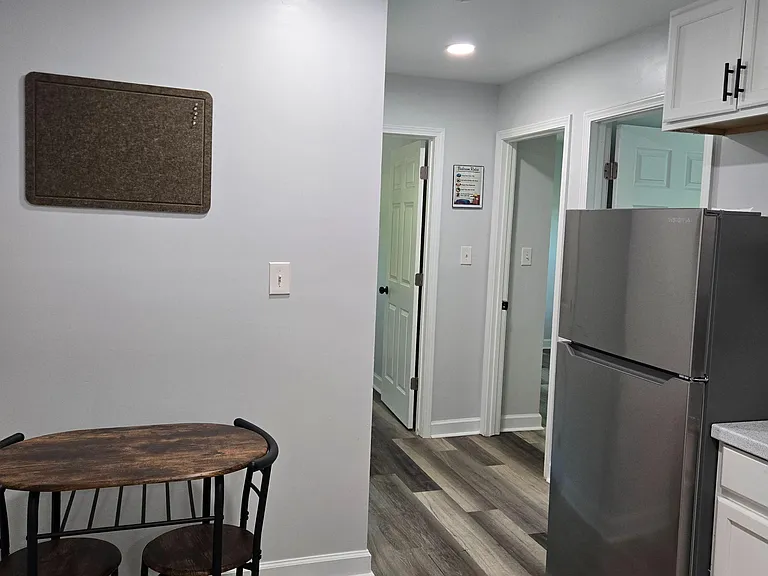 Kitchen area includes stainless steel refrigerator, ample cabinetry, and a small dining nook with easy access to nearby rooms