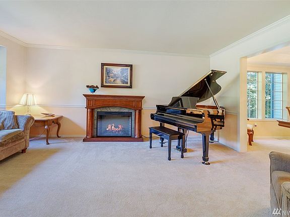 Formal living room with crown molding, chair rail and electric fireplace.