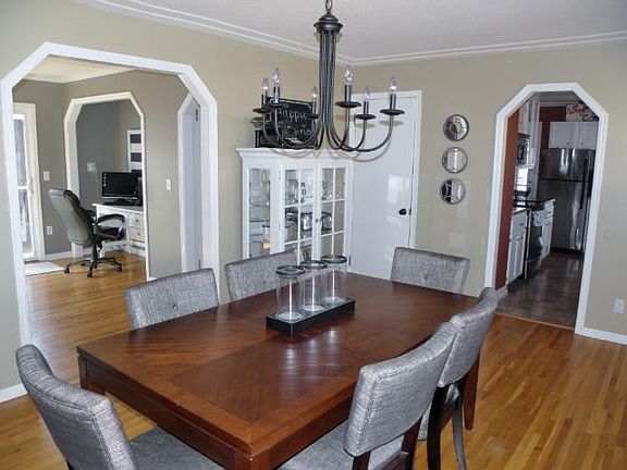Another view of dining room shows hardwood floors and arched doorways.