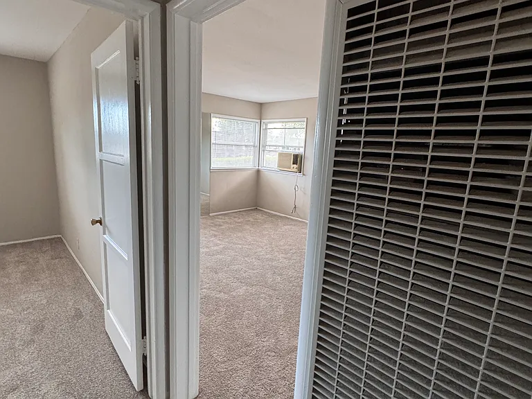 Hallway with the view of the living room and first bedroom entrance