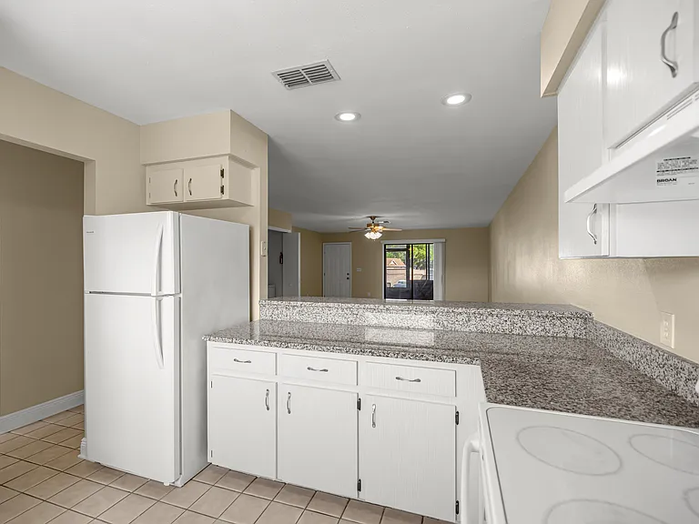 view from the kitchen sink to the refrigerator and dining room