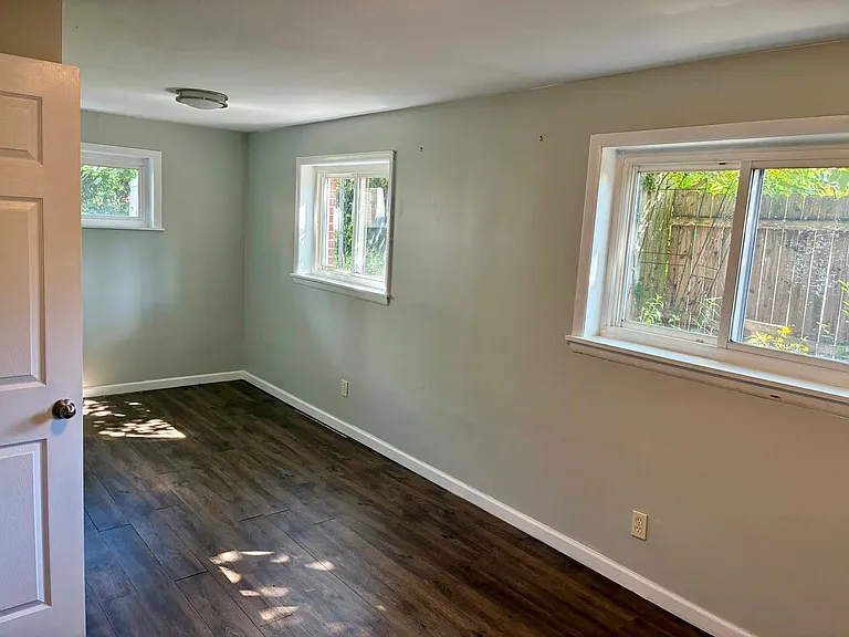 Lower level bedroom 1; looks out to backyard and small native flower garden along side of house.