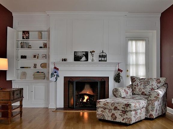 LIVING ROOM.  The beautiful hardwood in the living room is complemented by a gas fireplace with wood surround, engraved with den