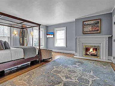 large bedroom with queen size poster bed and fireplace