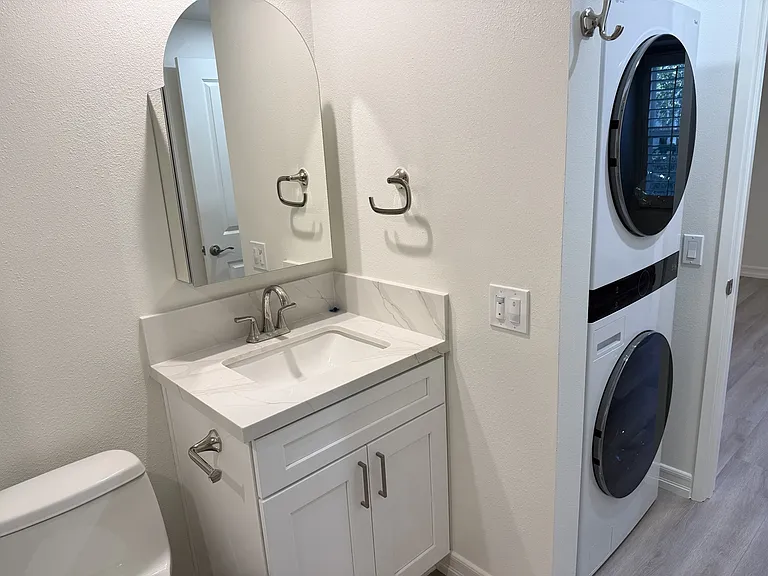 Premium Kohler vanity, mirrored medicine cabinet, and Vibrant Polished Nickel fixtures, plus a full-size LG washer & dryer.