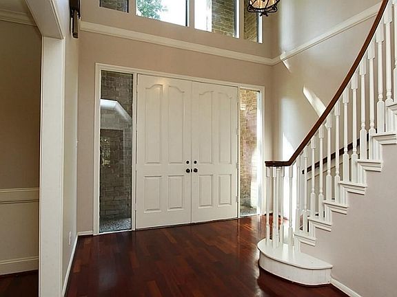 The two story foyer is very inviting with Brazilian cherry flooring, sweeping staircase and windows, both beside and above the door, to let in natural light.