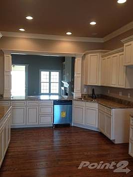 Custom "soft white" cabinets with granite countertops, hardwood floors and stainless steel appliances.