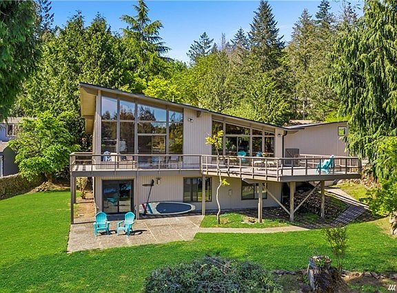 Welcome to Lakeside living.  Stunning Mid century design on large lot with 90+ feet no bank Lake front with sandy beach.