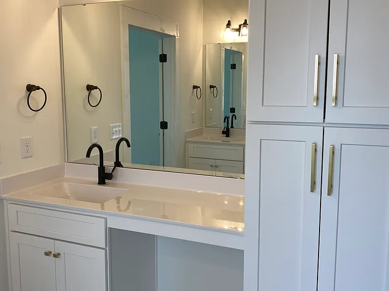 Master bathroom sink with vanity/make-up area and linen closet.