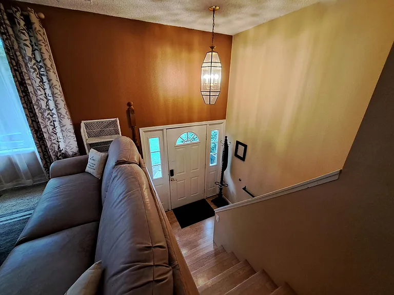 Looking down half flight to front door. Main living area is on the upper floor (kitchen, dining, living bath and 2 bedrooms). Downstairs has 2 bedrooms, bath/laundry.