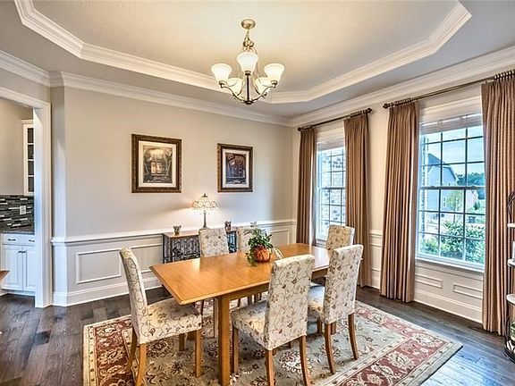 Wainscoting lines the elegant dining room with adjoining butler's pantry.