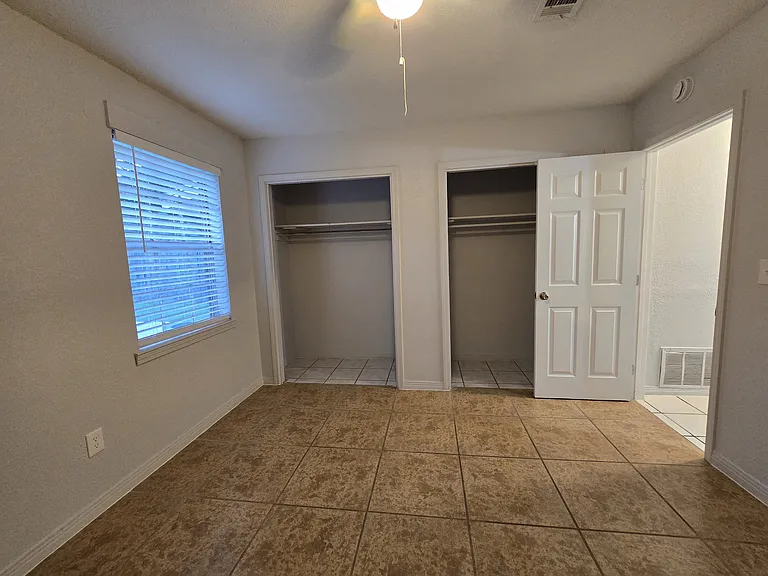 Large rear bedroom with window & ceiling fan plus plenty of closet space.