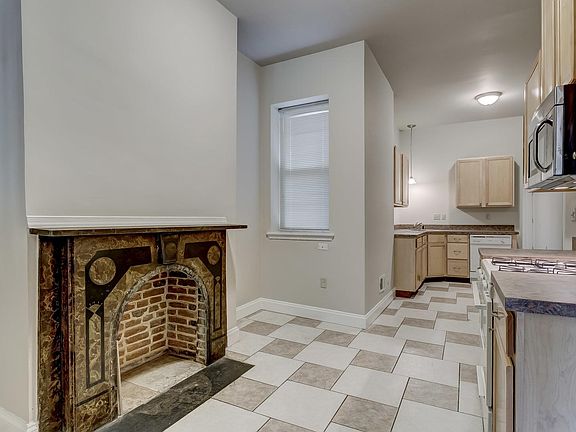 Large, open eat in country styled kitchen. Original fireplace details!