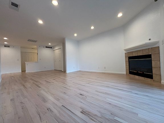 view of open living space, fireplace, main entrance, coat closet
