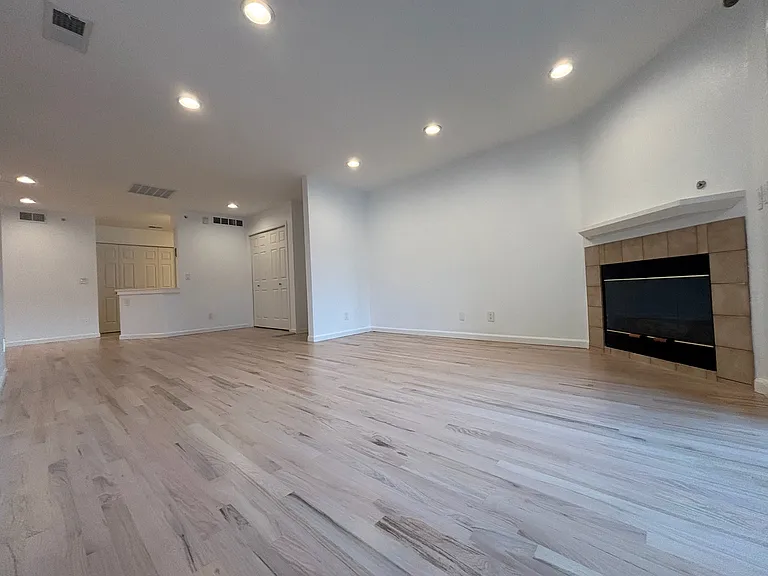 view of open living space, fireplace, main entrance, coat closet