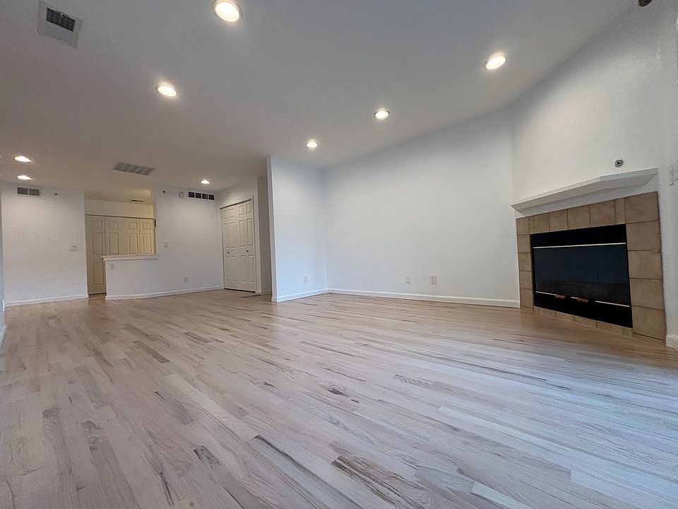 view of open living space, fireplace, main entrance, coat closet