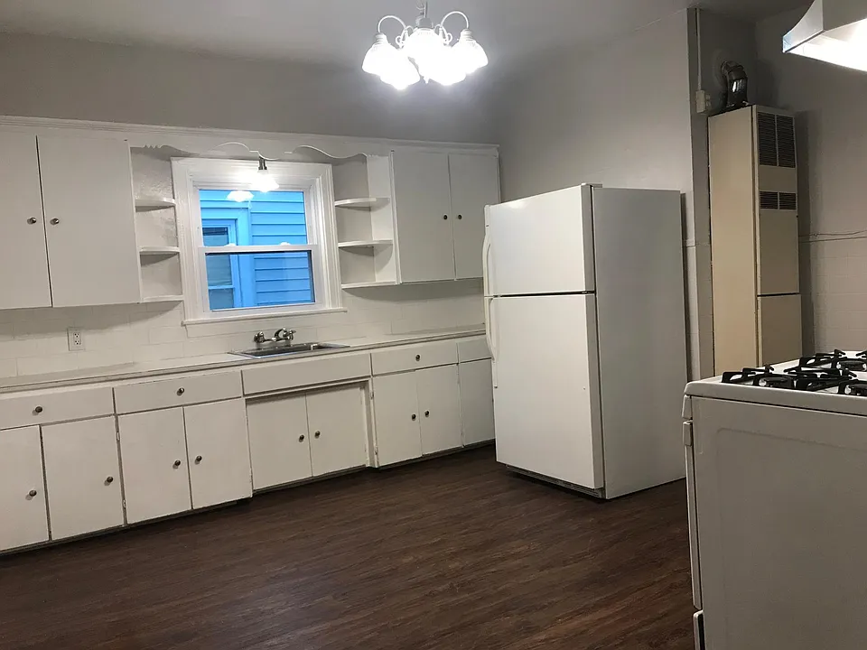 Renovated kitchen with a chandelier, lovely window with a light above the sink AND plenty of cabinets