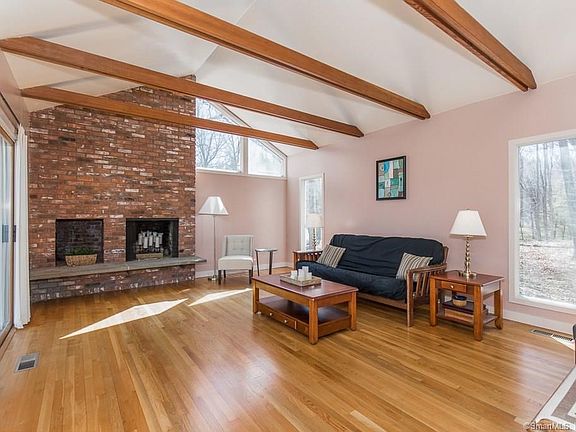 Living room with beautiful hardwood features fireplace and vaulted ceiling.