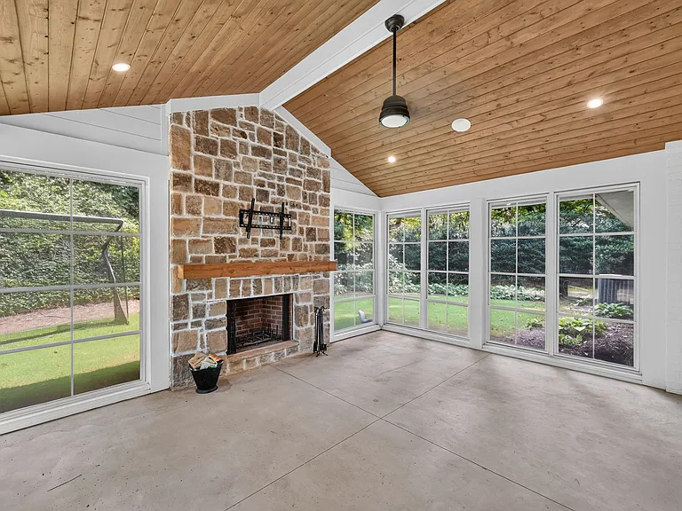Three season porch w/vauted ceilings, wood burning fireplace, ceiling fan, and window screens that easily slide open to let fresh air in or close to keep the elements out.