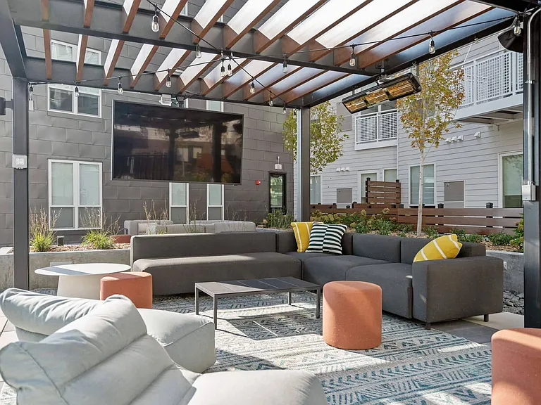 Shaded outdoor TV lounge on the rooftop amenity deck at The Hallon Luxury Apartments in Hopkins MN