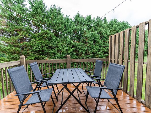 An outdoor dining table with bistro lights is on the porch just off of the kitchen, so that you can dine indoors or out.