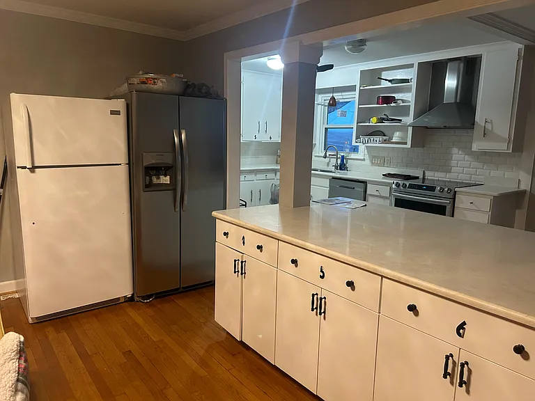 Kitchen with generous counter space, ample cabinetry, and a full appliance suite including dishwasher and range hood.