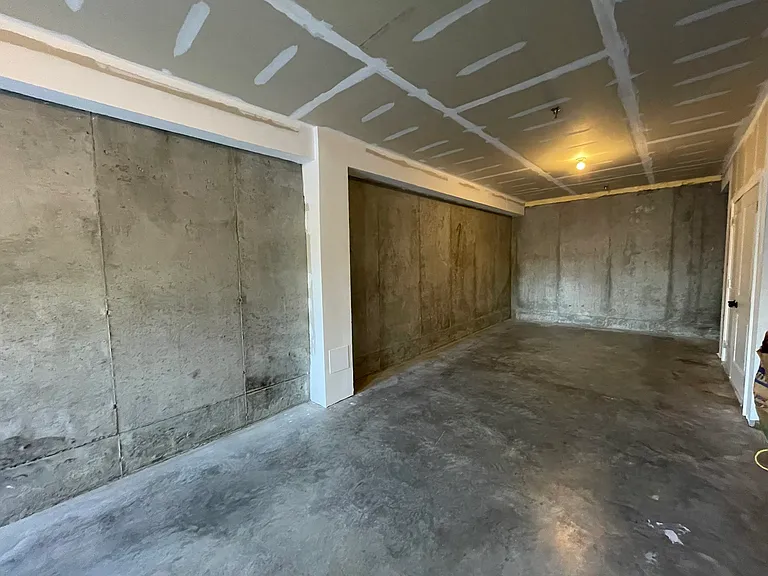 Two-car tandem garage with ample storage and EV charging.
