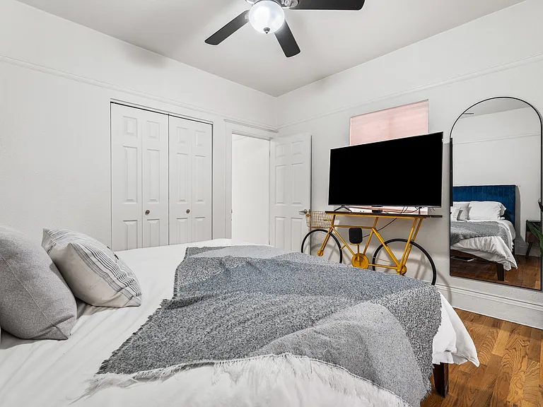 Spacious bedroom with hardwood floors and ample closet space (photographed with a king-size bed).